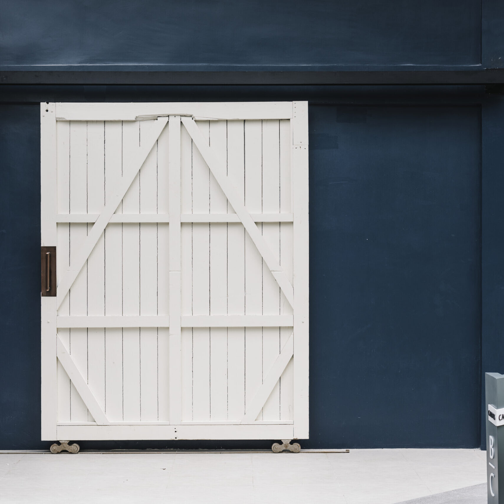 Wooden white door on a blue building wall